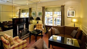 Una sala de estar acogedora con chimenea, un sofá, un sillón y una mesa de centro.