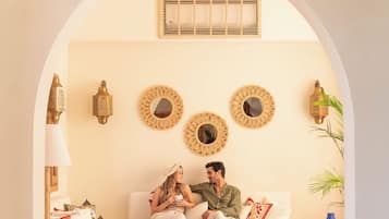A cozy living room with a checkered floor, a hanging lantern, and decorative mirrors on the wall.