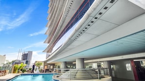 Een modern hotel met een zwembad, terras en uitzicht op de stadshemel.