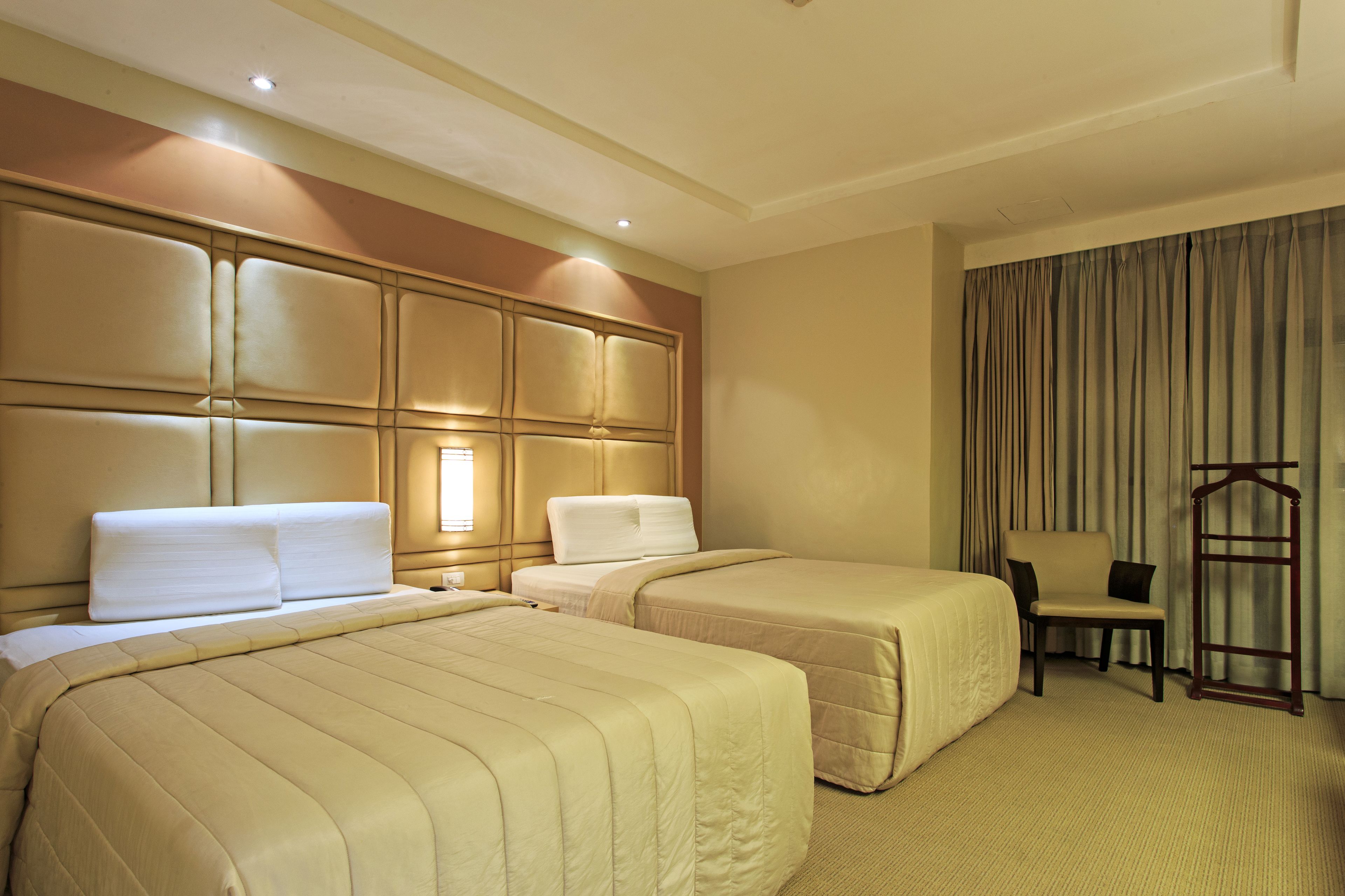Een hotelkamer met twee bedden, een stoel en een kledingkast.
