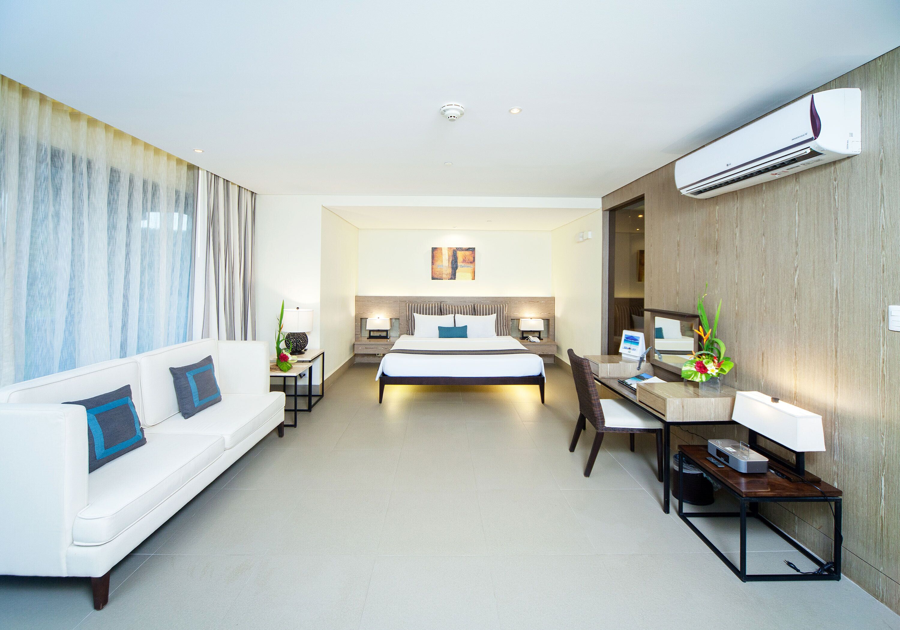 Une chambre d’hôtel moderne équipée d’un lit, d’un canapé, d’un bureau et d’une chaise.