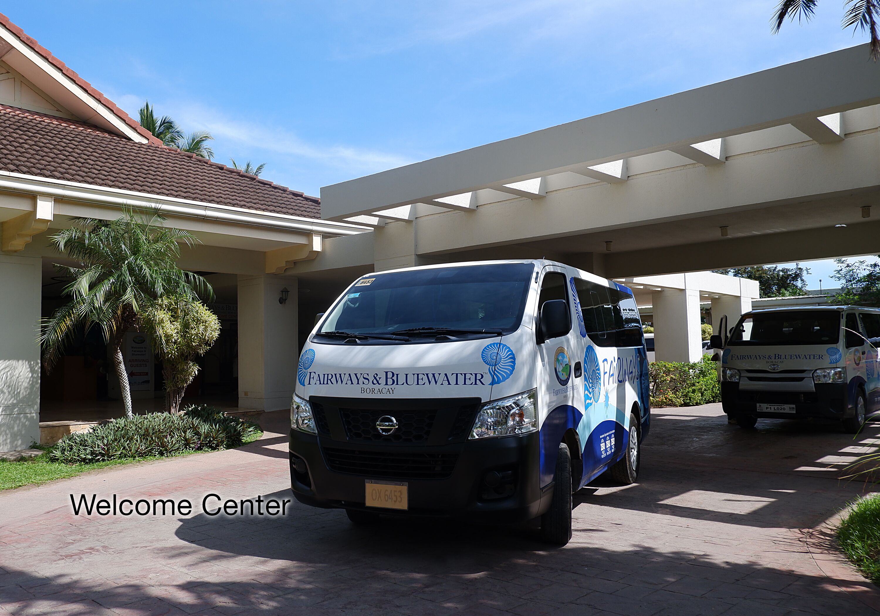 A van parked in front of a building with a sign reading "Welcome Center".