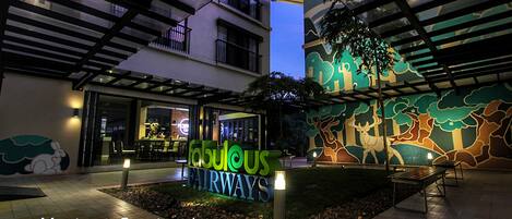 A courtyard with a sign reading "Fabulous Fairways," benches, and a mural.
