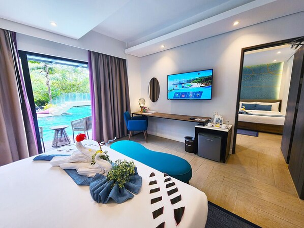 A modern hotel room with a large bed, a desk, a TV, and a view of the outdoors.
