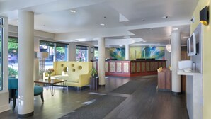 A spacious lobby with a reception desk, seating area, and large windows. - The Belltown Inn (Seattle)