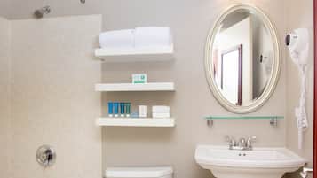 A bathroom with a toilet, sink, mirror, and towel rack.
