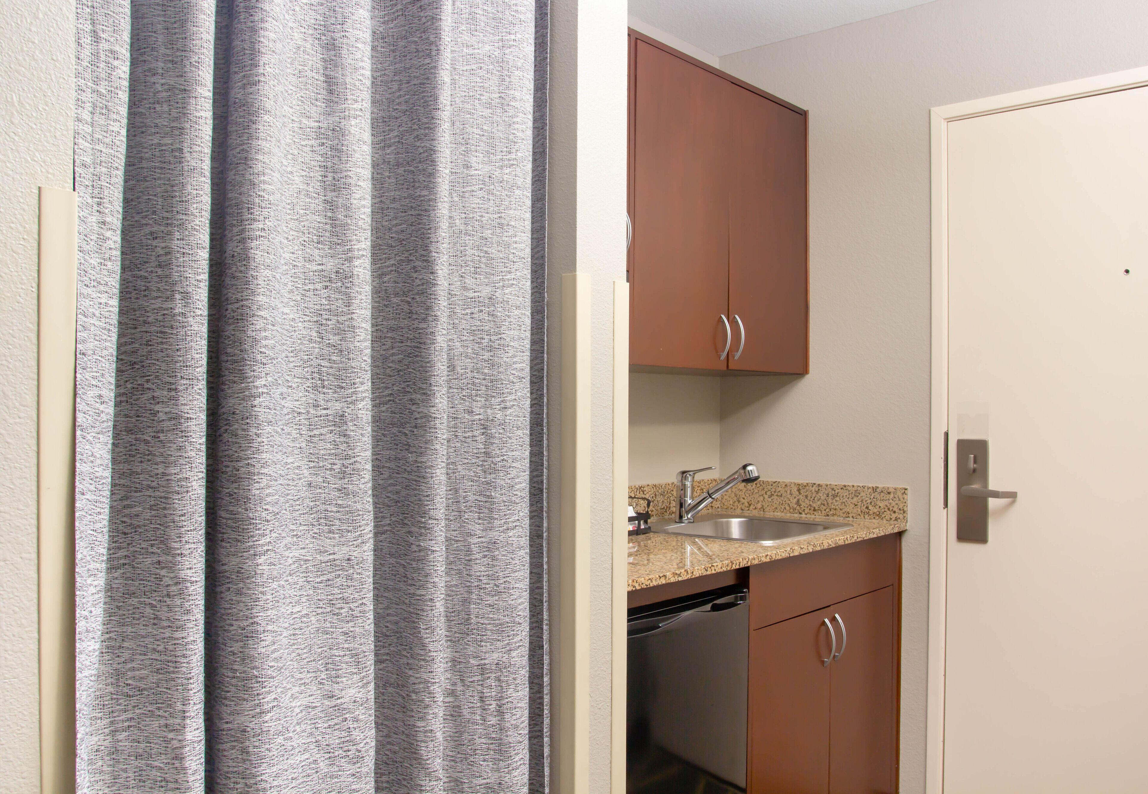A kitchen with a sink, cabinets, and a dishwasher.