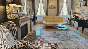 Una sala de estar con sofá, sill ón y una mesita de centro.