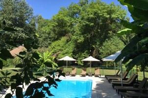 Una piscina al aire libre de temporada, sombrillas