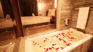 A bathroom with a bathtub, a mirror, and a shower.