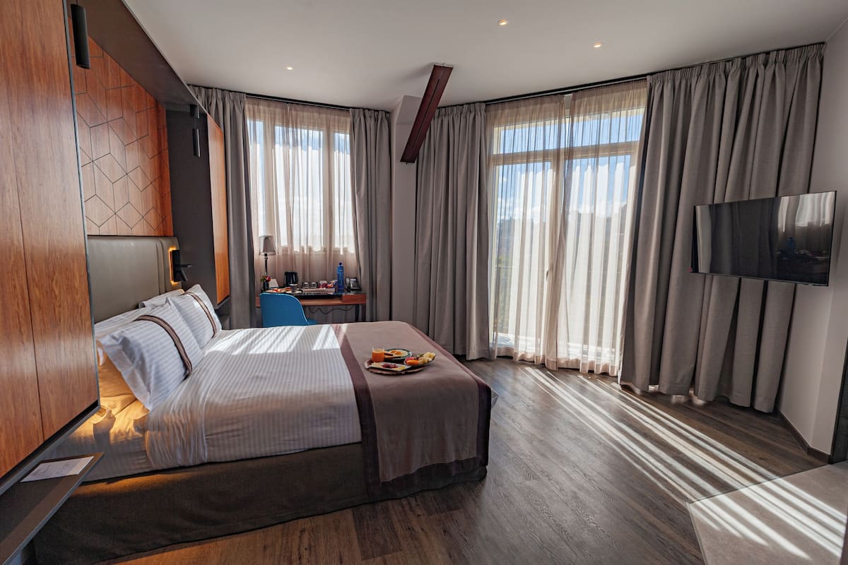 Deluxe kamer | Luxe beddengoed, een minibar, een kluis op de kamer, een bureau