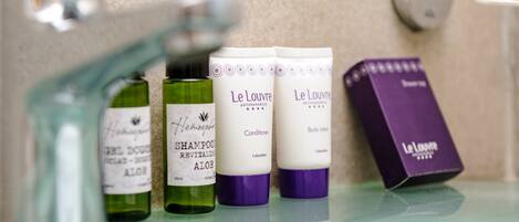 Ein Badezimmerschrank mit verschiedenen Produkten von Le Louver, darunter Shampoo, Conditioner und Körperlotion.