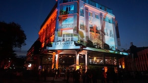 A multi-story hotel with a prominent sign reading "Le Louvre Hotel & Spa."