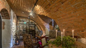 A cozy, brick-walled room with a wine rack, comfortable seating, and candles. - Gripsholms Värdshus (Mariefred)