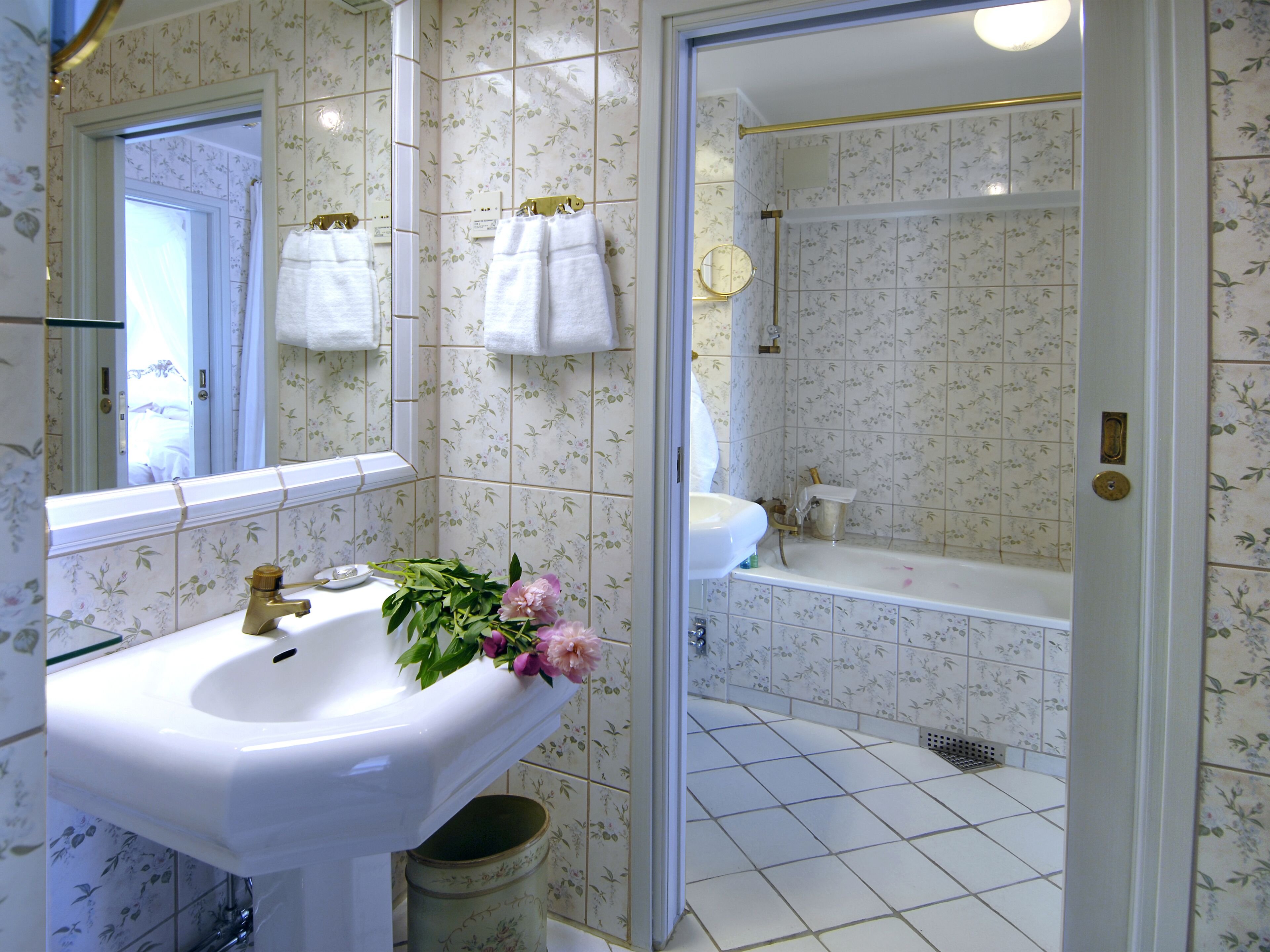Un baño con lavamanos, espejo y ducha.