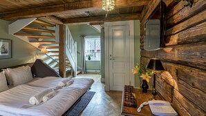 A cozy room with a bed, a desk with a telephone, and a wooden wall. - Gripsholms Värdshus (Mariefred)