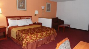 A hotel room with a large bed, a desk, and a chair.