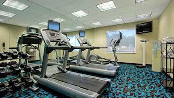 A fitness center with treadmills, a stair climber, and dumbbells.
