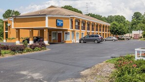A Rodeway Inn with a two-story building, a parking lot, and a few cars parked in front. - Rodeway Inn Laurens (Laurens)