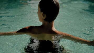 A person in a swimming pool with clear water.