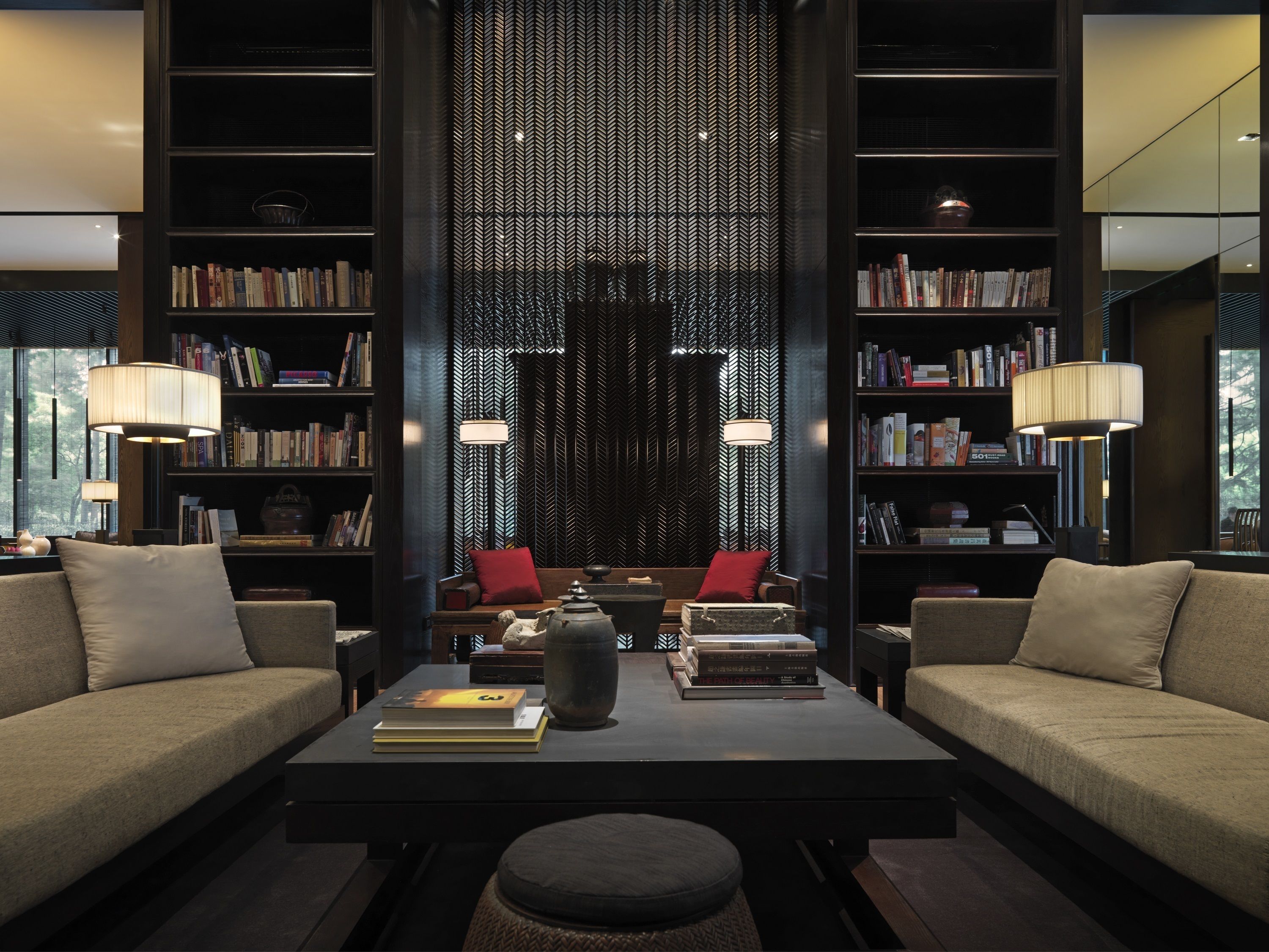 A modern living room with a sofa set, a coffee table, and two bookshelves filled with books.