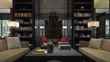 A modern living room with a sofa set, a coffee table, and two bookshelves filled with books.
