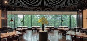 A spacious dining area with large windows, wooden tables, and hanging pendant lights. -  The PuLi Shanghai  (Shanghai)