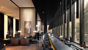 Eine moderne Hotelhalle mit einer langen Rezeption, einer Sitzecke und großen Fenstern mit Blick ins Freie.