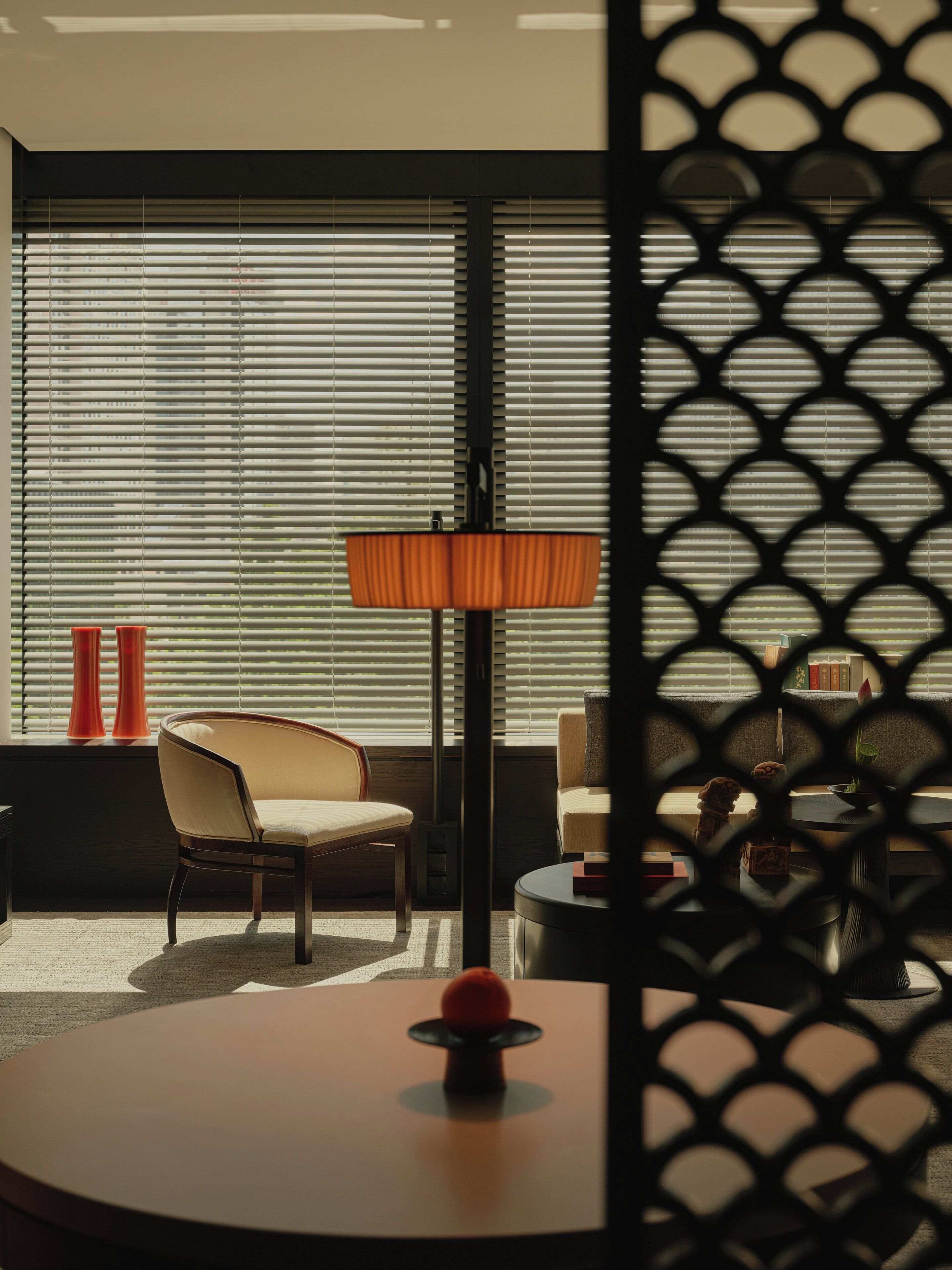 A modern room with a large window, a round table, and two chairs.