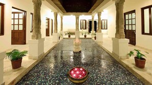 A corridor with tiled flooring, columns, and doors. - Fort Khejarla, Jodhpur (Bilara)