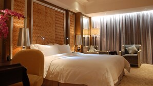 Una habitación de hotel con una cama grande, una silla, un escritorio y una lámpara.
