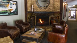 Un rincón tranquilo con sillones de cuero, una mesa de centro de madera y una chimenea.