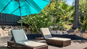 Una piscina al aire libre, sillones reclinables de piscina