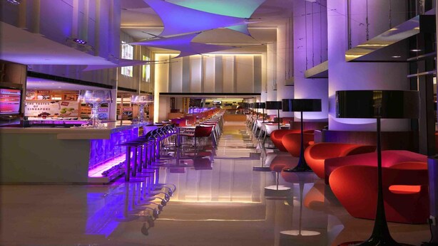 Un interior moderno con una zona de bar, asientos y una escalera.