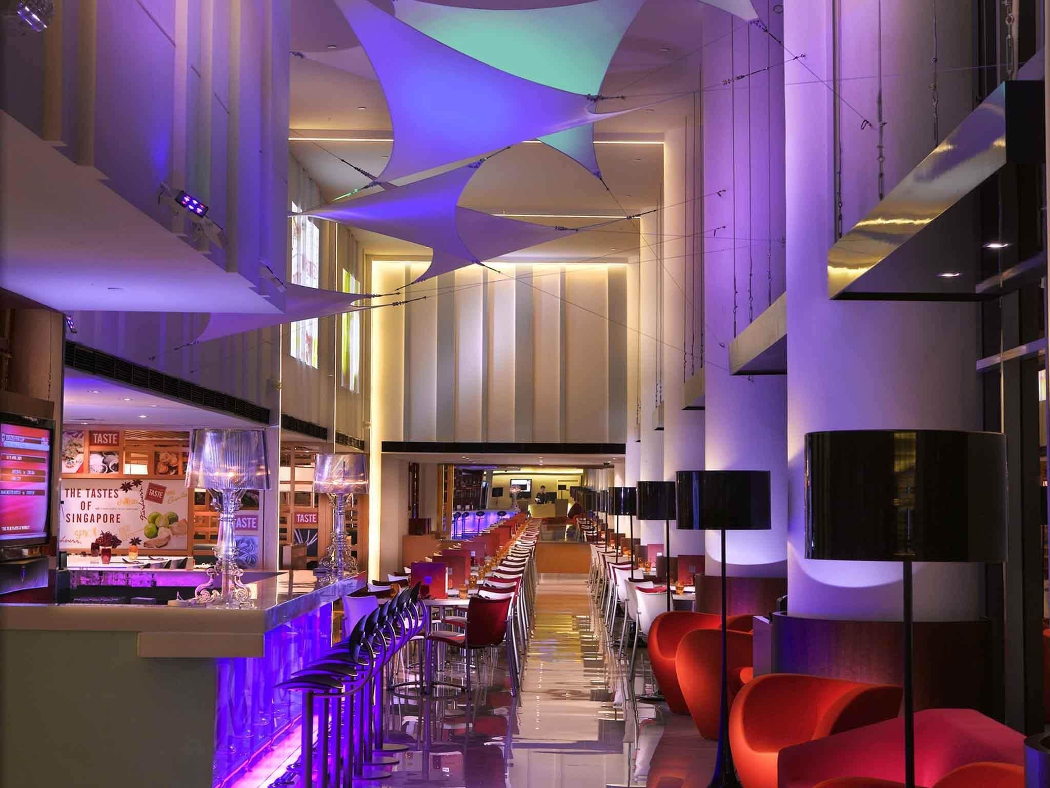 Un interior moderno con una barra alargada, asientos y un espacio central abierto.