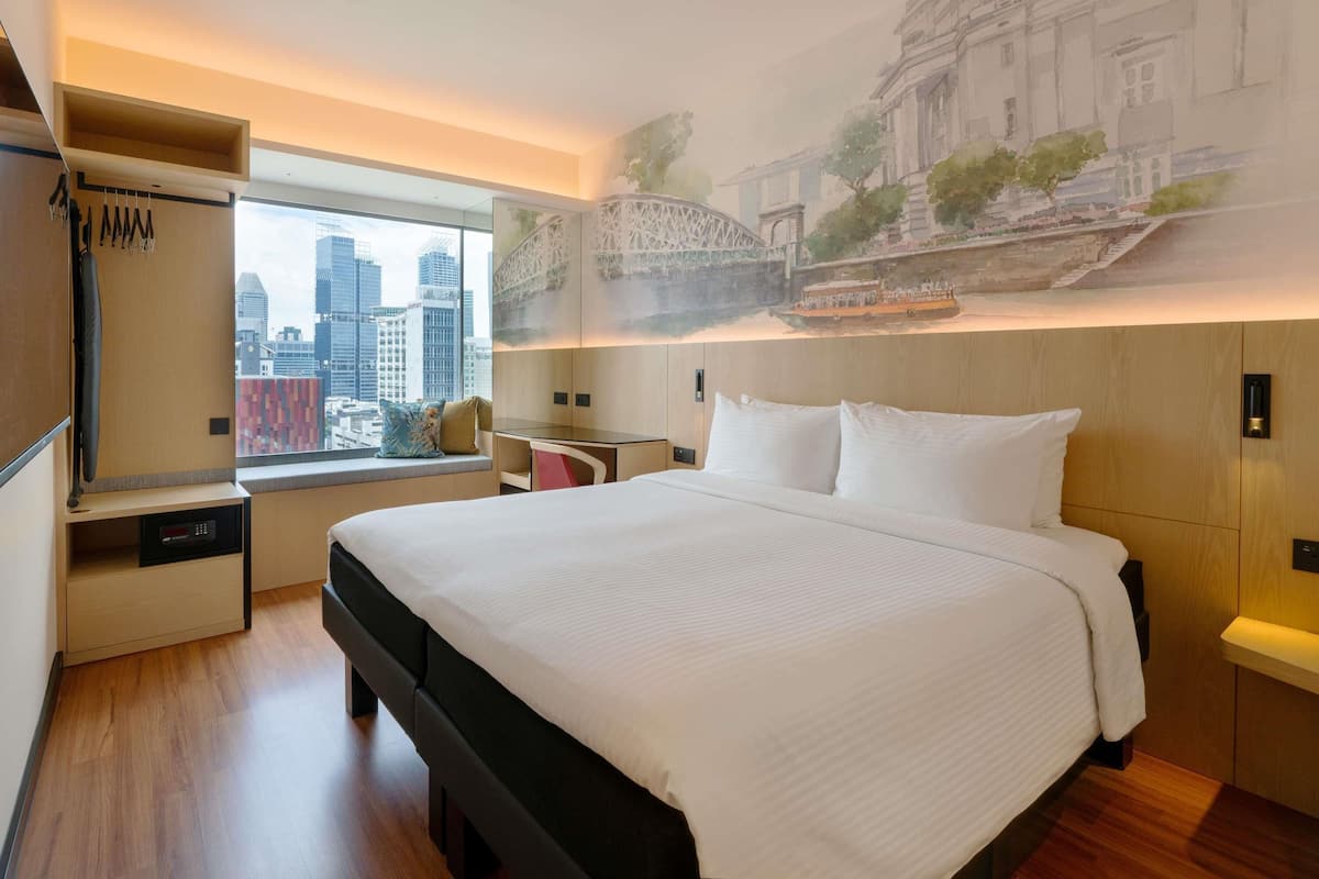 Una habitación de hotel moderna con una cama grande, vistas a la ciudad, un mural de un puente y un armario.