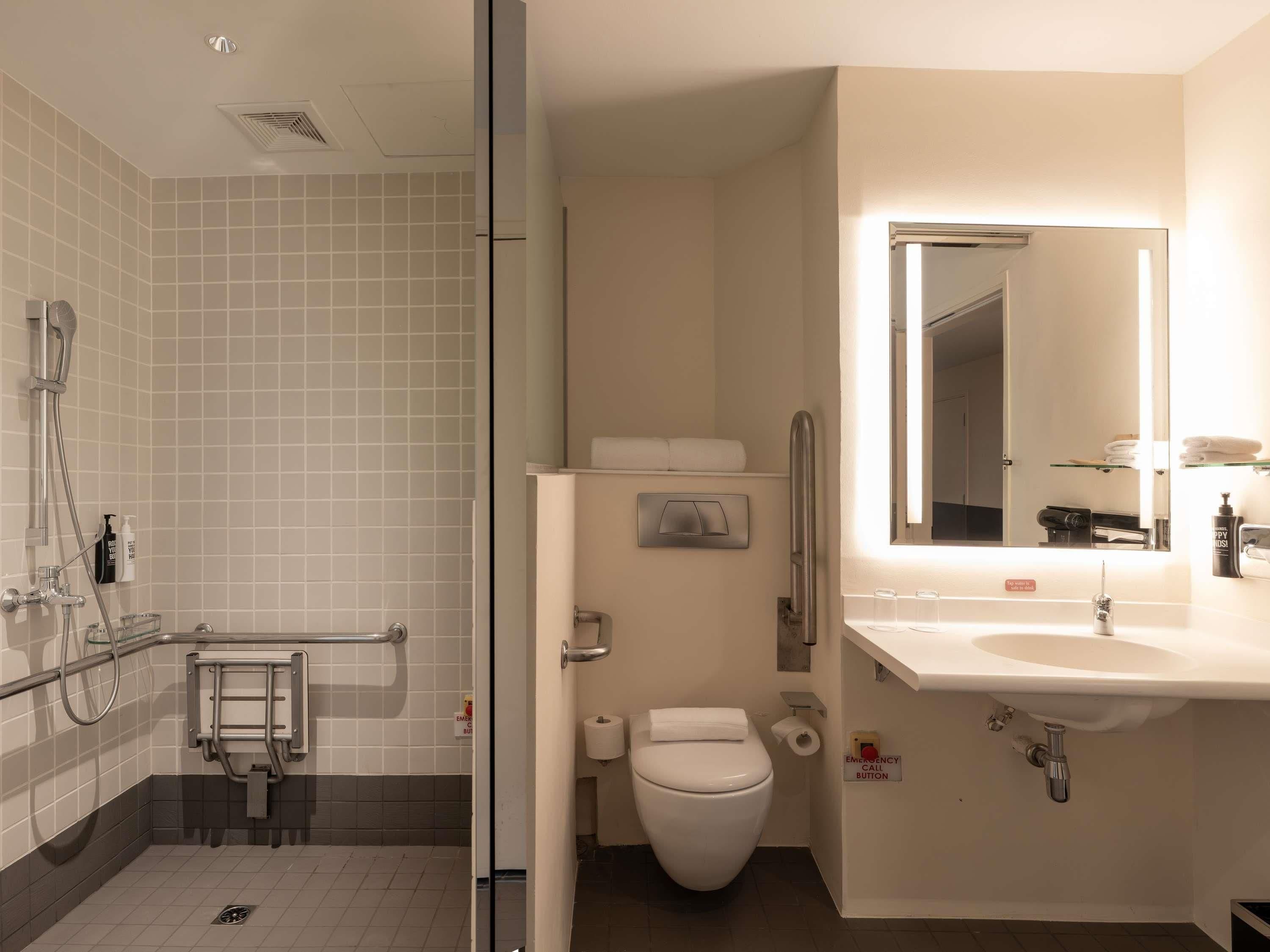 Un baño con ducha, inodoro, lavabo y espejo.
