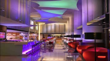 A modern interior with a bar area, seating, and a staircase.