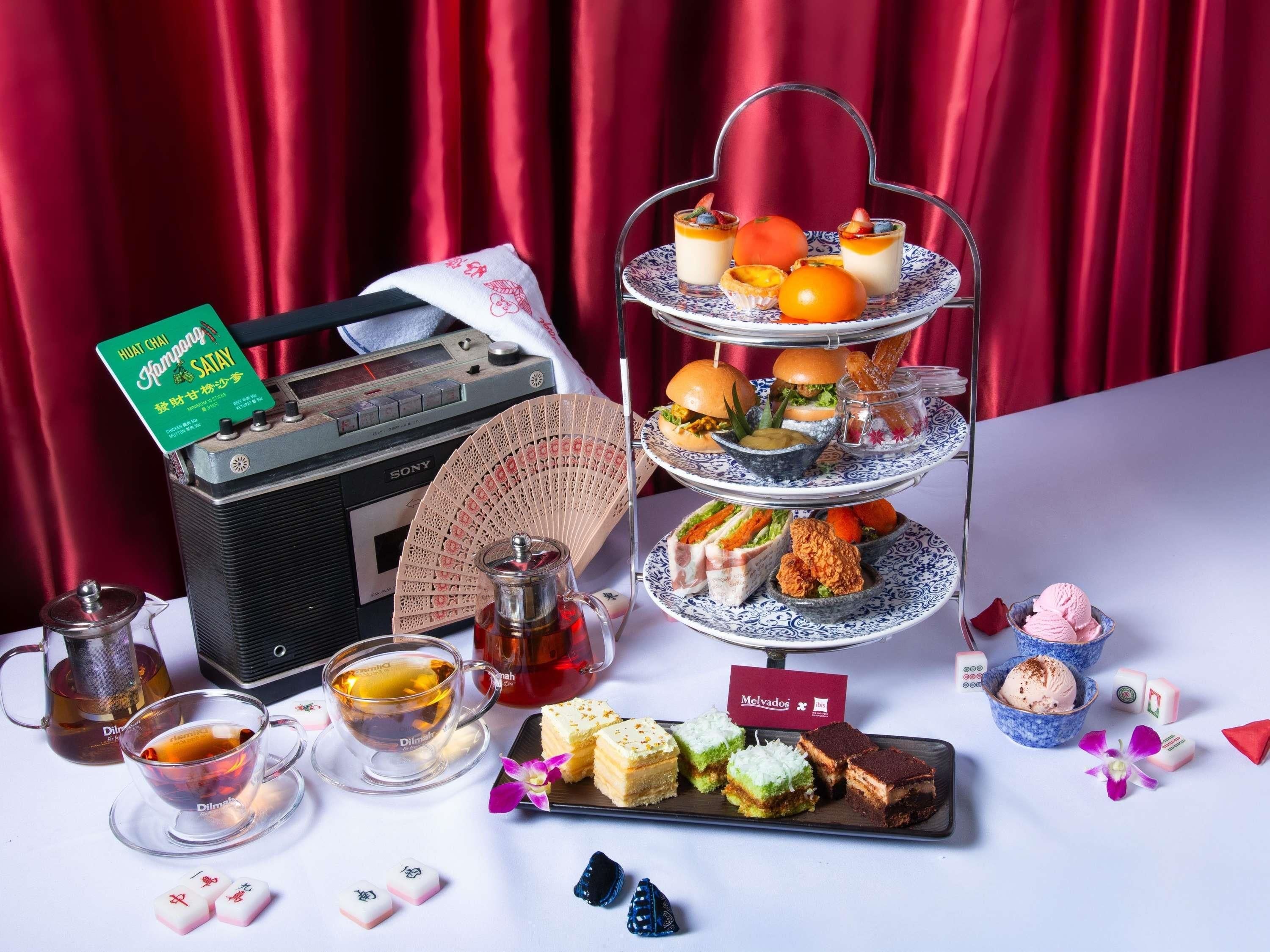Un soporte escalonado para postres con diversos dulces, una radio antigua y vajillas de té.