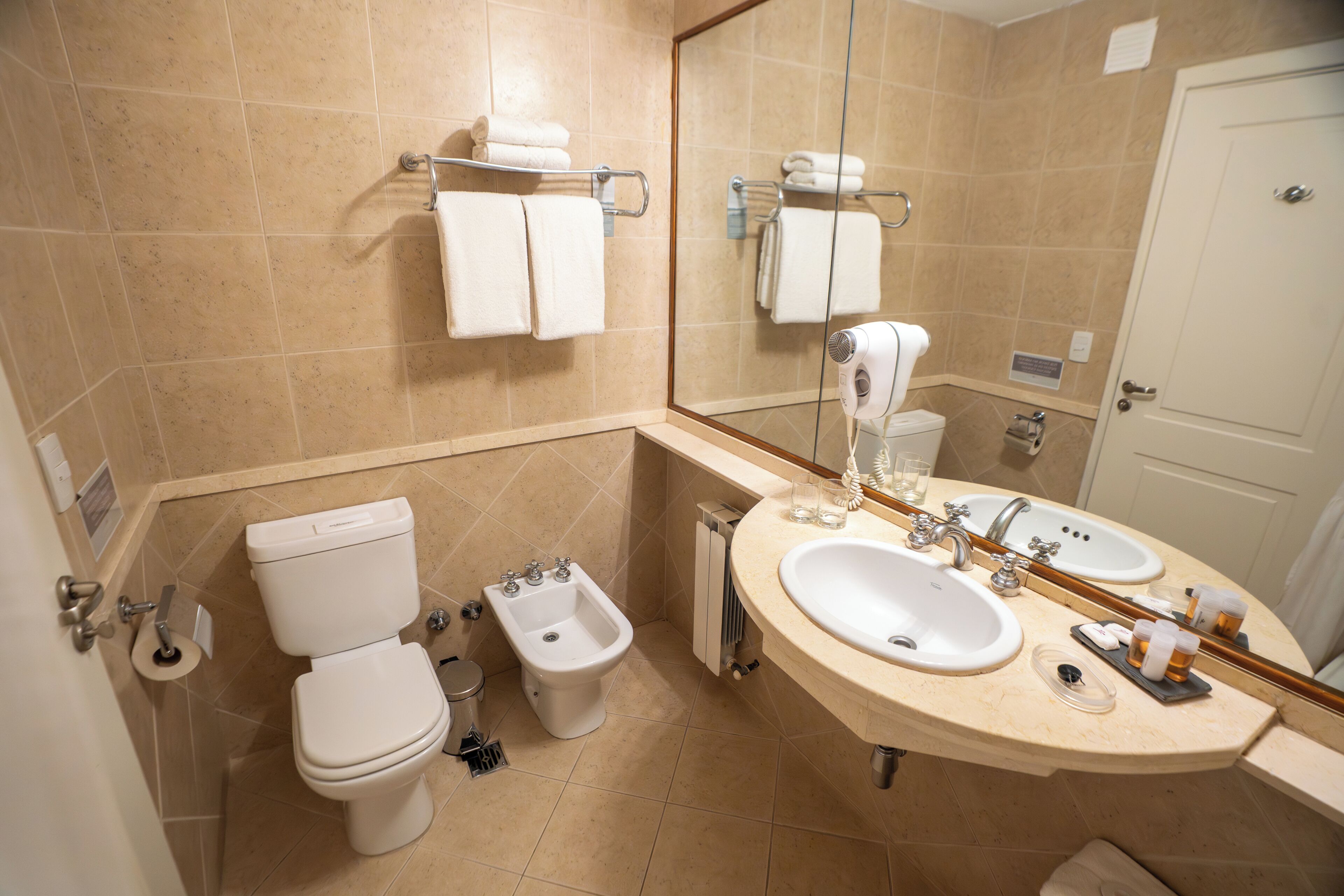 Un baño con inodoro, lavabo y espejo.