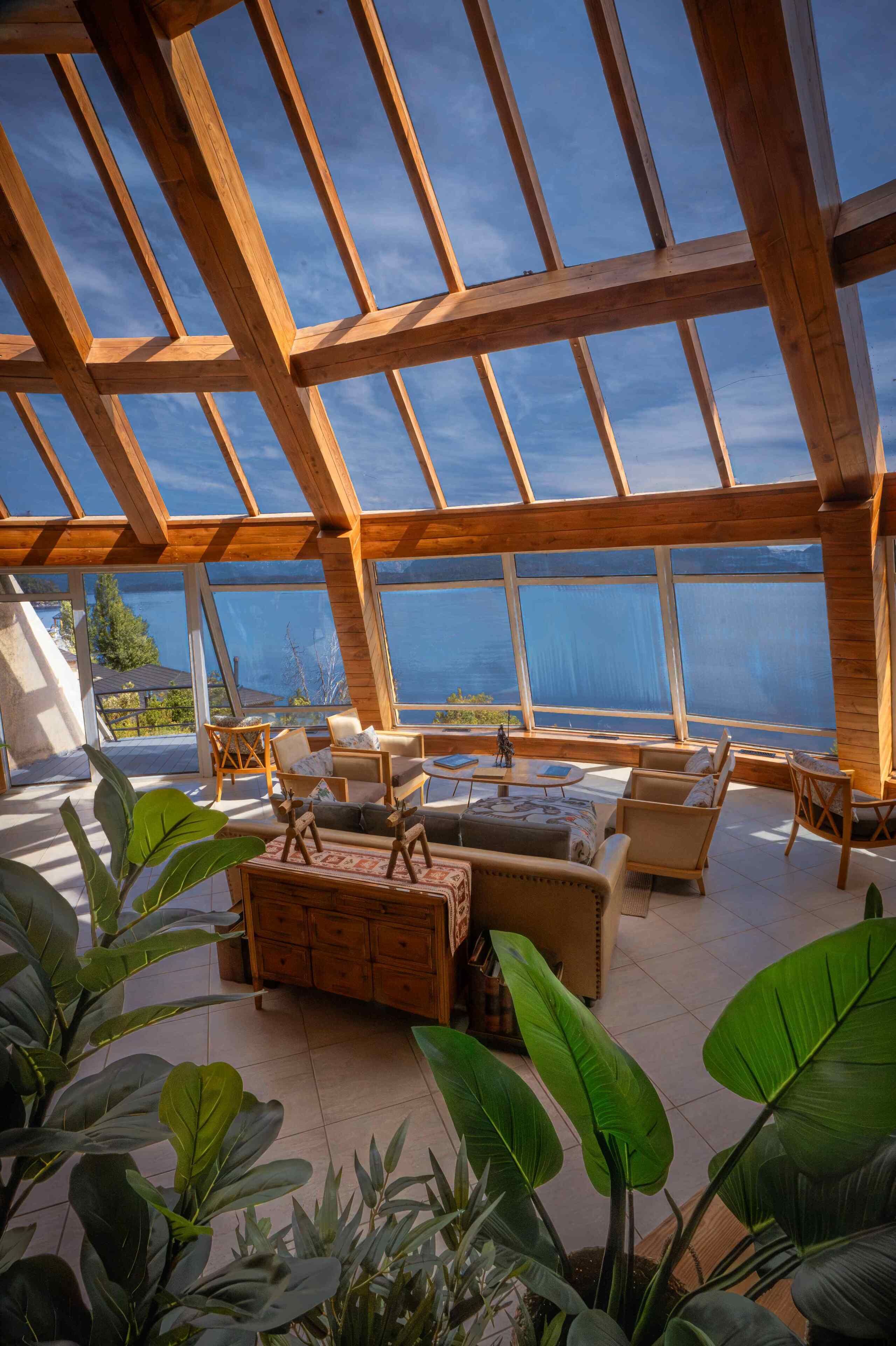 Una habitación amplia con techo alto, ventanas grandes y vistas al exterior.
