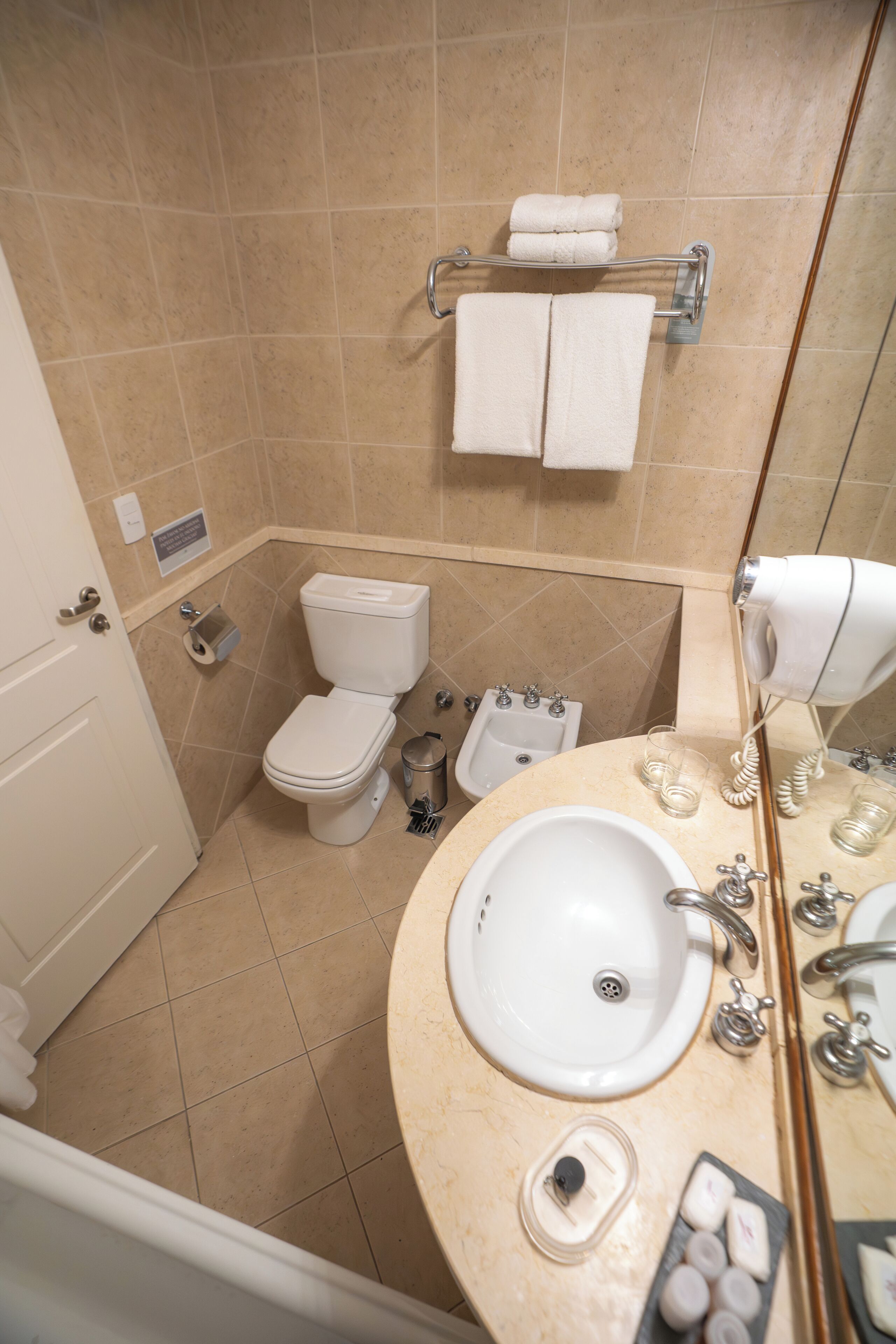 Ein Badezimmer mit Toilette, Bidet, Waschbecken und Handtuchhalter.