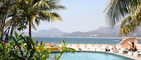 Una piscina al aire libre, sillones reclinables de piscina