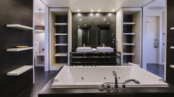 A modern bathroom with a large bathtub, two sinks, and a large mirror.
