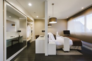 A modern bedroom with a bed, bedside table, and a large mirror.
