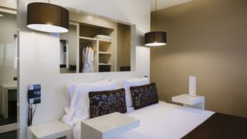 Una habitación de hotel moderna con una cama grande, mesitas de noche, un espejo y un armario.