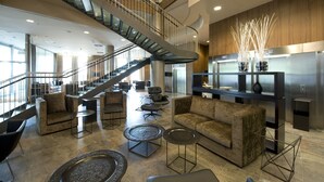 Un hall d’entrée spacieux, doté d’un escalier moderne, de coins salon confortables et d’un comptoir d’accueil contemporain.