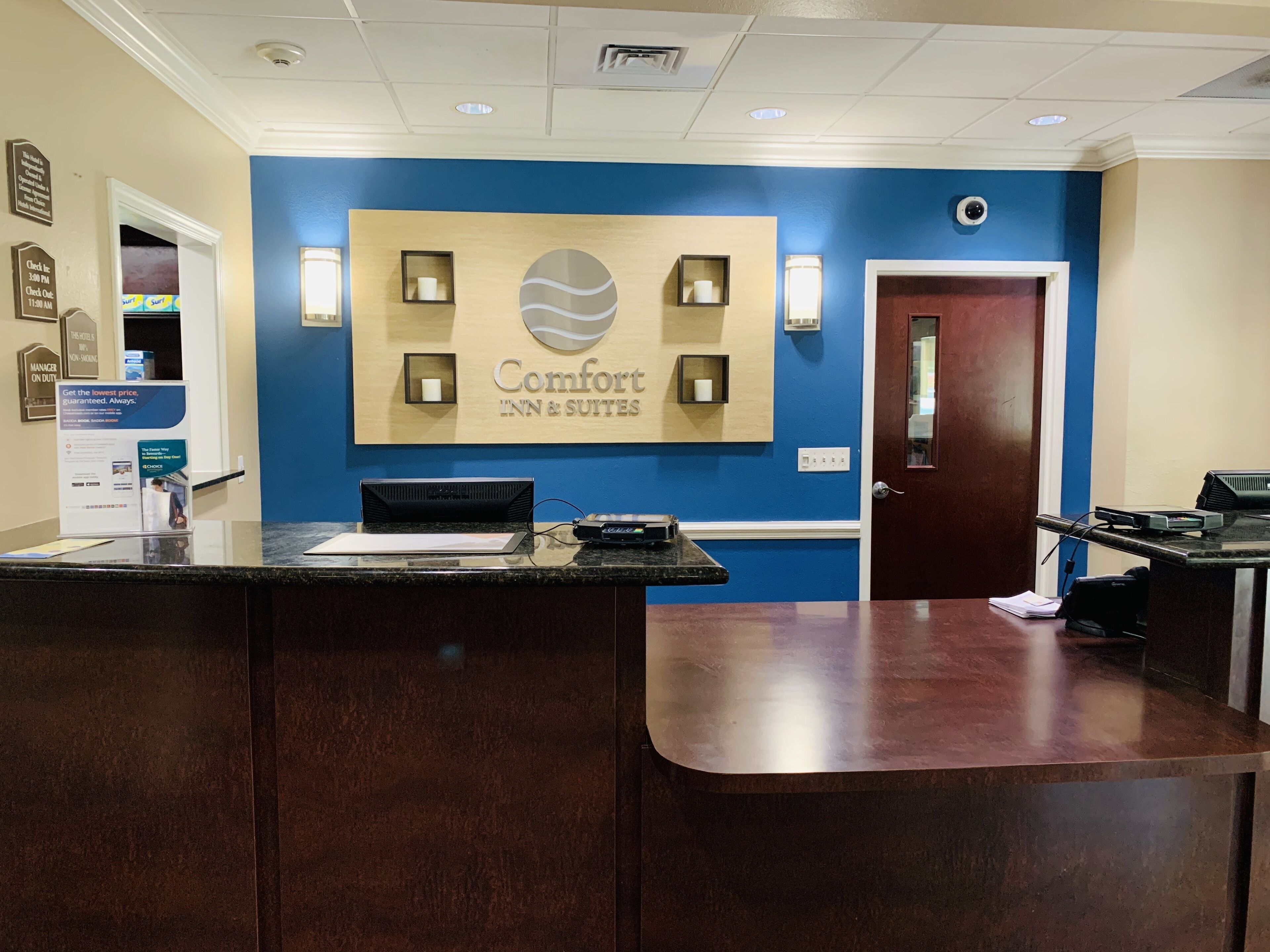 Una reception hotel con una parete blu e un cartello che riporta "Comfort Inn & Suites".