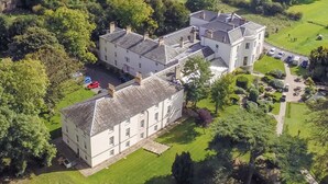 A large, historic building with multiple wings and a well-maintained lawn. - Owston Hall Hotel (Doncaster)