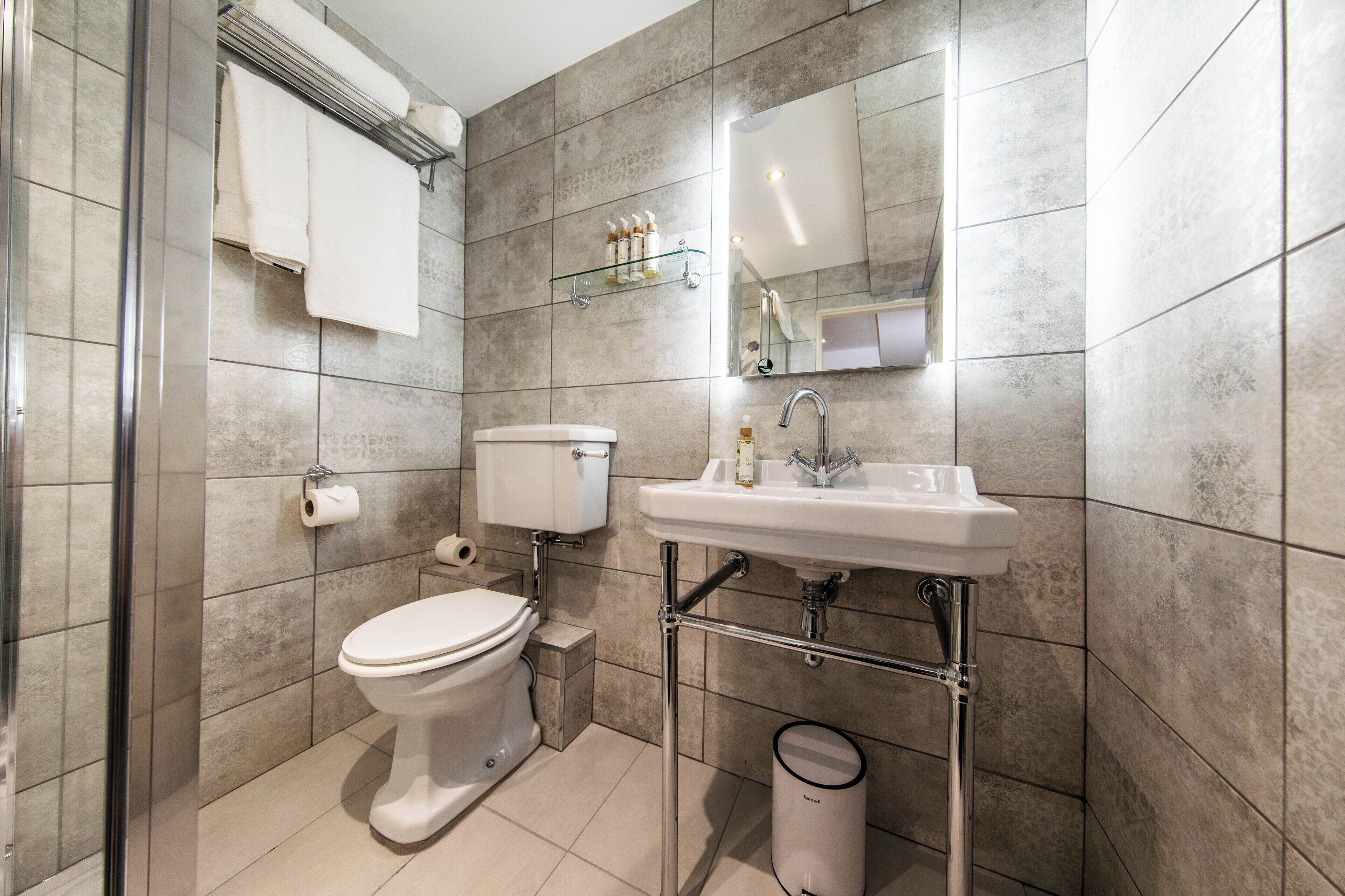 A modern bathroom with a toilet, sink, and shower area.